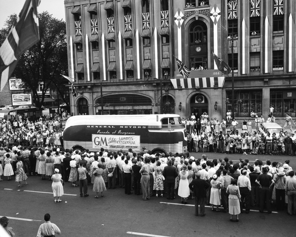 PRODUCT EXPERT NOTE: 1955 view of a 1940 GM Futurliner in a P.O.P. parade ENVELOPE INFO: 7-20-55; 4x5 pub. views of Parade of Progress; @ London, Ont.ORIGINAL CLIENT: GM Pub. RelationsSIGN: "General Motors Parade of Progress Salutes London Centennial..."RESEARCH NOTE: The brainchild of Charles Kettering, the Parade of Progress brought Worlds Fair type non-commercial entertaining, educational exhibitions to rural and small towns across the USA using custom-built Streamliners (1935-1940) and Futurliners (1940s and 1950s). [SOURCE: GM Text File]