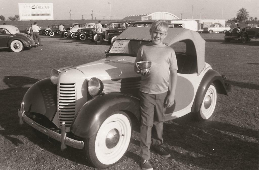 Craig at 10 years old with his first restoration, a 1939 American Austin Bantam.