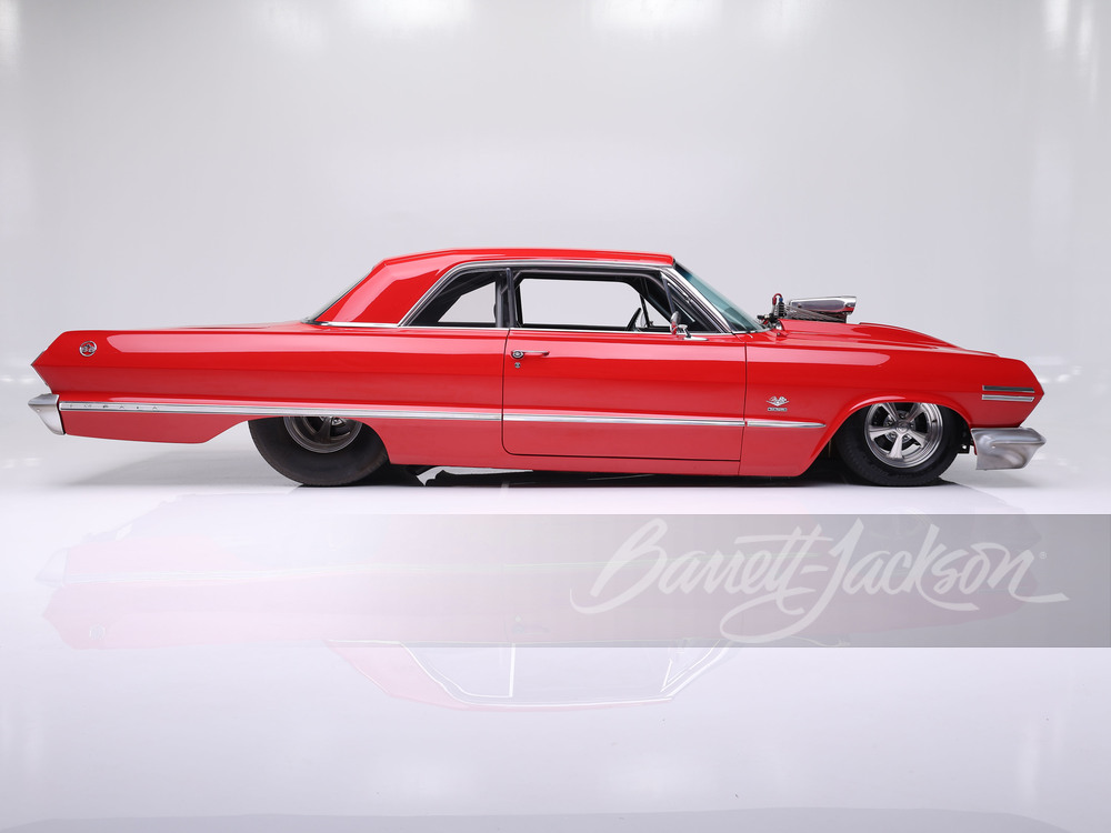 Side profile of the 1963 Chevrolet Impala Sport Coupe showing its distinctive bubbletop fastback roofline beneath the channeled, lowered stance
